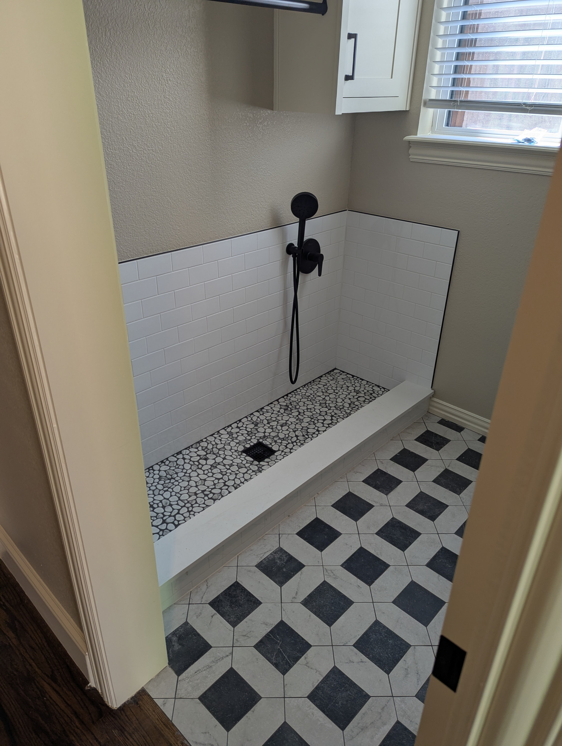 AFTER, (almost) check out the beautiful tile work! Subway tile for the backsplash, stonework for the puppy's pads and classic tile for the rest of the laundry room.
