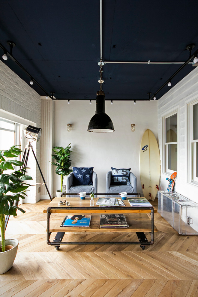 Photo of an industrial living room in Tokyo with white walls and light hardwood floors.