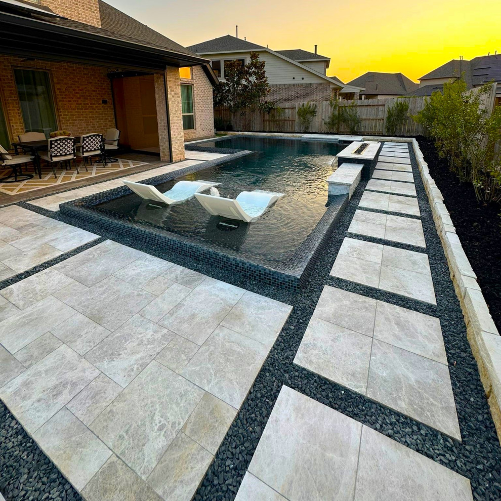 Modern l-shaped swimming pool in Houston with natural stone paving.