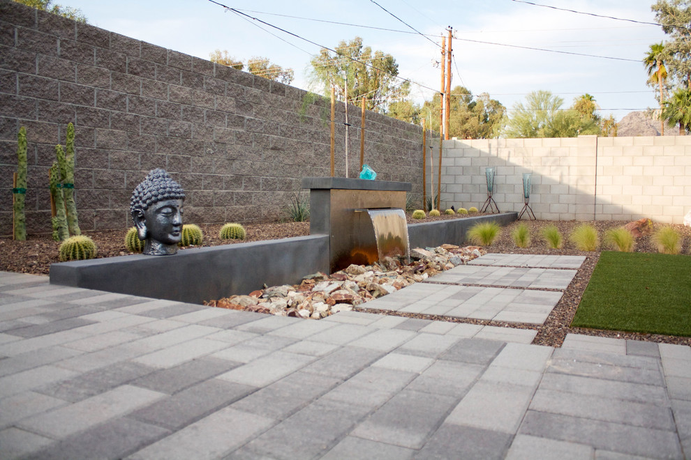Inspiration for a mid-sized modern backyard full sun xeriscape for spring in Salt Lake City with a water feature and brick pavers.