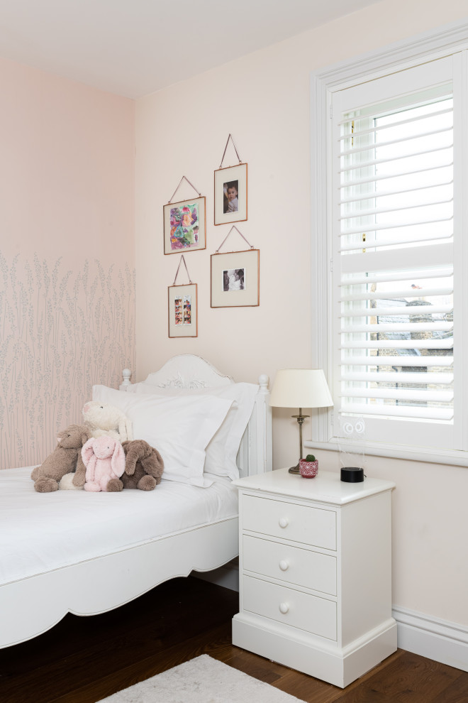 Design ideas for a transitional kids' bedroom for girls in London with pink walls, dark hardwood floors and brown floor.