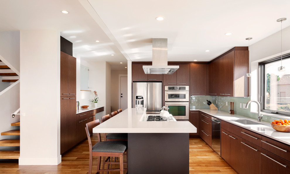 Trendy medium tone wood floor kitchen photo in Denver with flat-panel cabinets, dark wood cabinets, an island, an undermount sink and stainless steel appliances