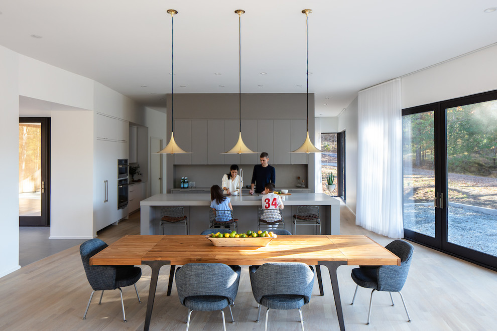Design ideas for a modern eat-in kitchen in Raleigh with an undermount sink, flat-panel cabinets, grey cabinets, grey splashback, light hardwood floors, with island, beige floor and grey benchtop.
