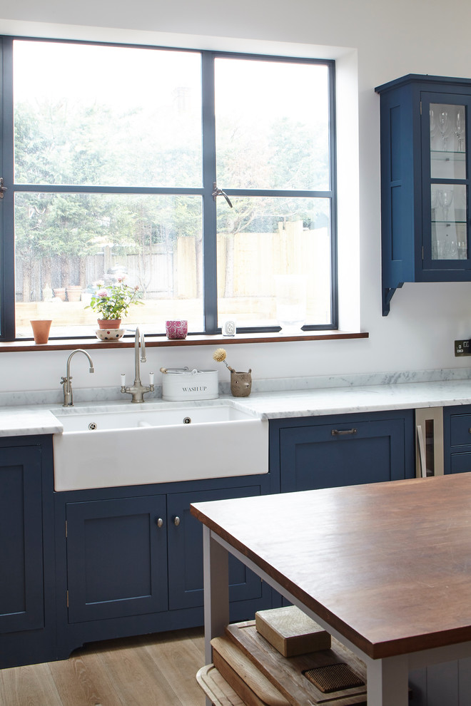 Design ideas for a traditional eat-in kitchen in Surrey with shaker cabinets and with island.