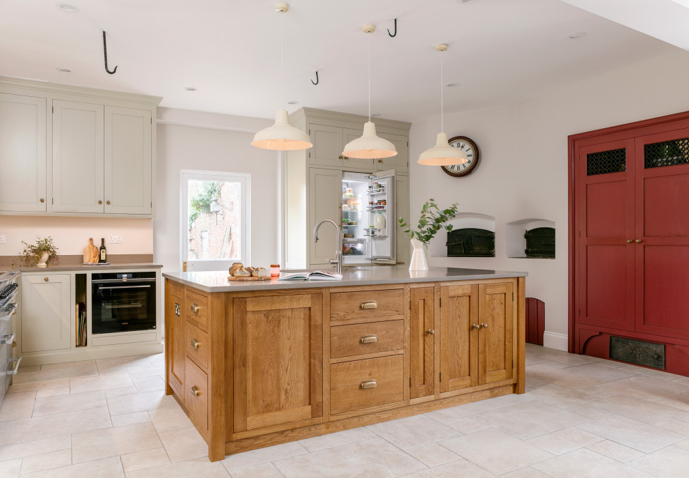 This is an example of a country u-shaped kitchen in West Midlands with shaker cabinets, with island, grey cabinets, black appliances, beige floor and grey benchtop.