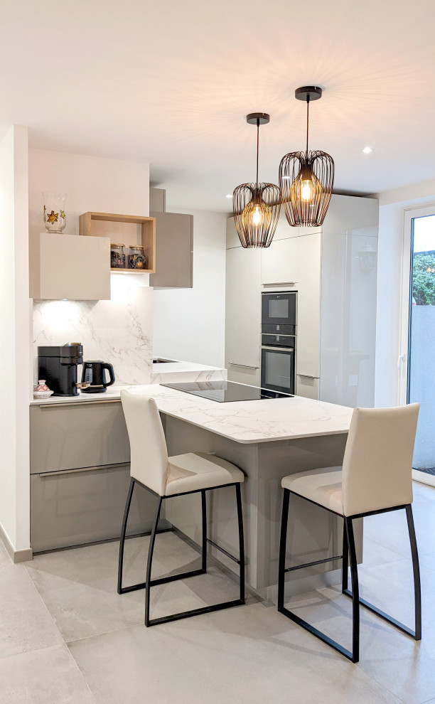 Photo of a mid-sized modern galley open plan kitchen in Other with an integrated sink, beaded inset cabinets, grey cabinets, quartz benchtops, white splashback, engineered quartz splashback, black appliances, ceramic floors, a peninsula, grey floor and white benchtop.