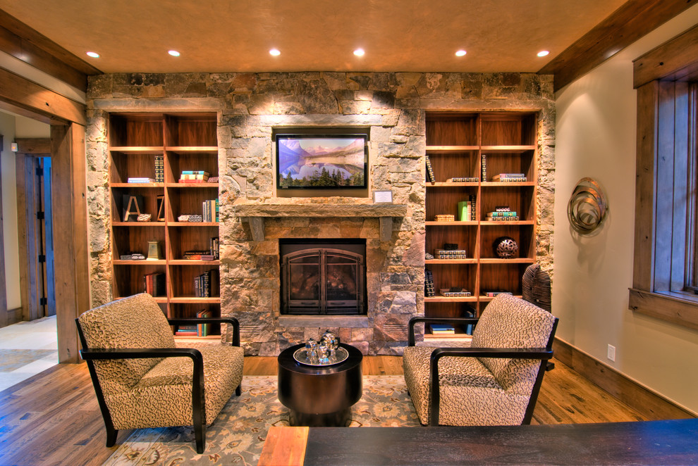 Photo of a mid-sized country loft-style family room in Salt Lake City with beige walls, light hardwood floors, a standard fireplace, a stone fireplace surround and a wall-mounted tv.