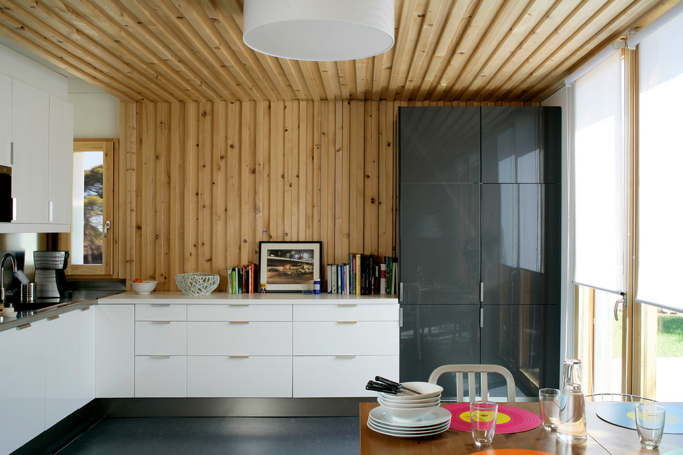 Photo of a mid-sized contemporary l-shaped eat-in kitchen in Barcelona with flat-panel cabinets, white cabinets, ceramic floors and no island.