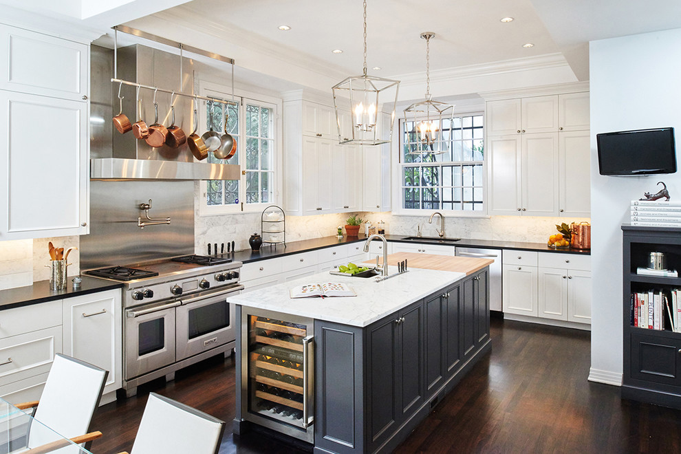 Large transitional dark wood floor eat-in kitchen photo in Los Angeles with an undermount sink, recessed-panel cabinets, white cabinets, white backsplash, stone tile backsplash, stainless steel appliances, an island and granite countertops