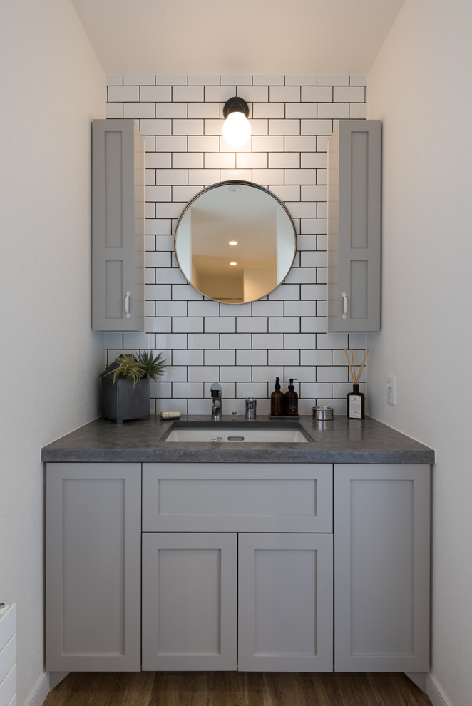 Design ideas for a midcentury powder room in Sapporo with recessed-panel cabinets, grey cabinets, white tile, subway tile, white walls, a drop-in sink and brown floor.