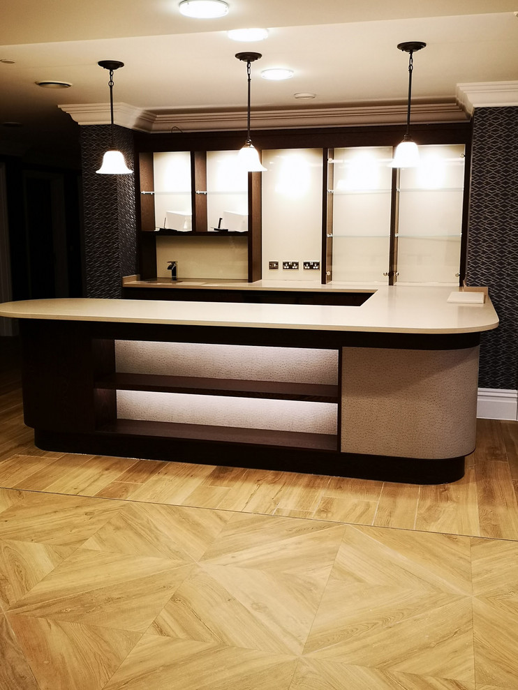 Large contemporary u-shaped home bar in Berkshire with dark wood cabinets.