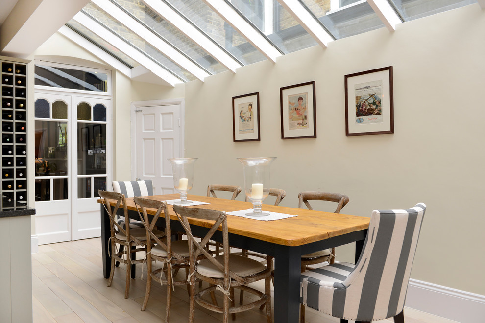 Inspiration for a traditional dining room in London with beige walls and light hardwood floors.