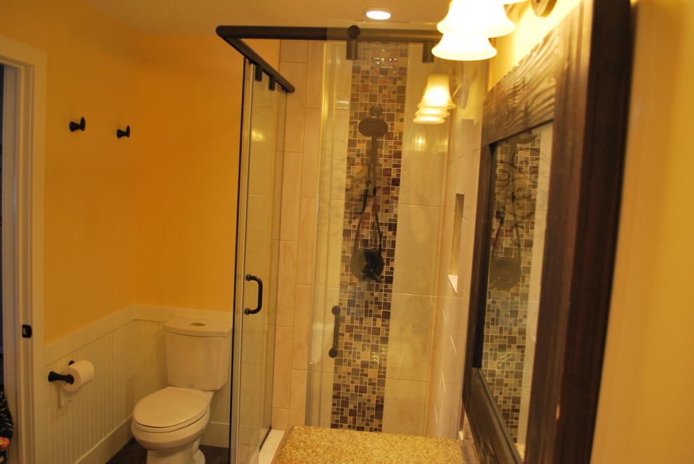 Mid-sized mountain style 3/4 multicolored tile and stone tile dark wood floor and brown floor freestanding bathtub photo in Calgary with a two-piece toilet, yellow walls, shaker cabinets, dark wood cabinets, an undermount sink and limestone countertops