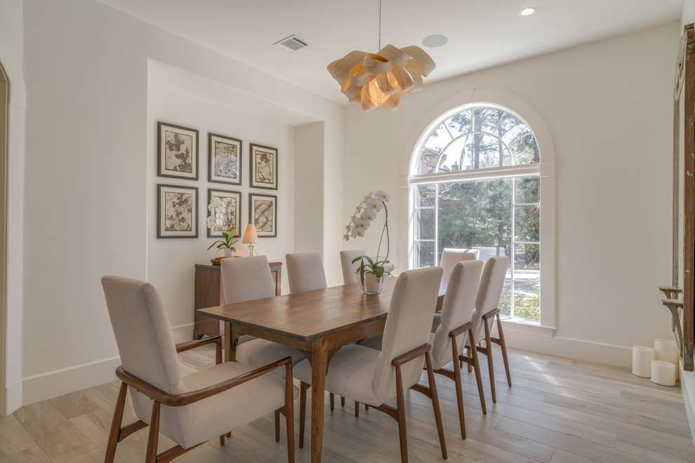 Mid-sized transitional dining room in Houston with white walls, light hardwood floors, no fireplace and beige floor.