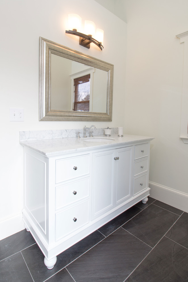Mid-sized traditional master bathroom in Atlanta with recessed-panel cabinets, white cabinets, a freestanding tub, a curbless shower, a two-piece toilet, white tile, ceramic tile, white walls, porcelain floors, an undermount sink and marble benchtops.
