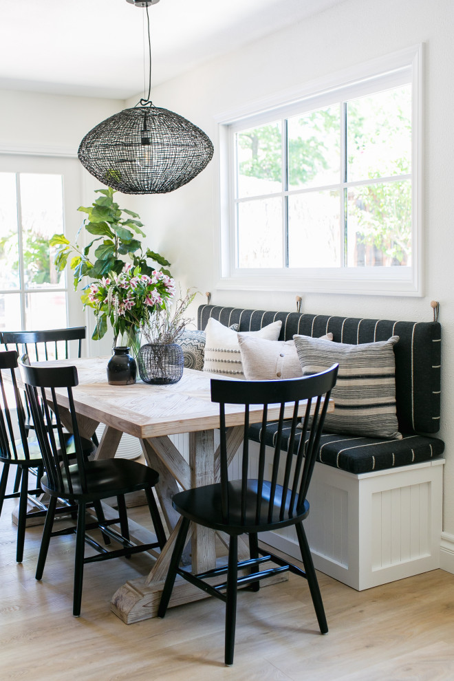 Inspiration for a small beach style dining room in San Diego with white walls, light hardwood floors, no fireplace and beige floor.