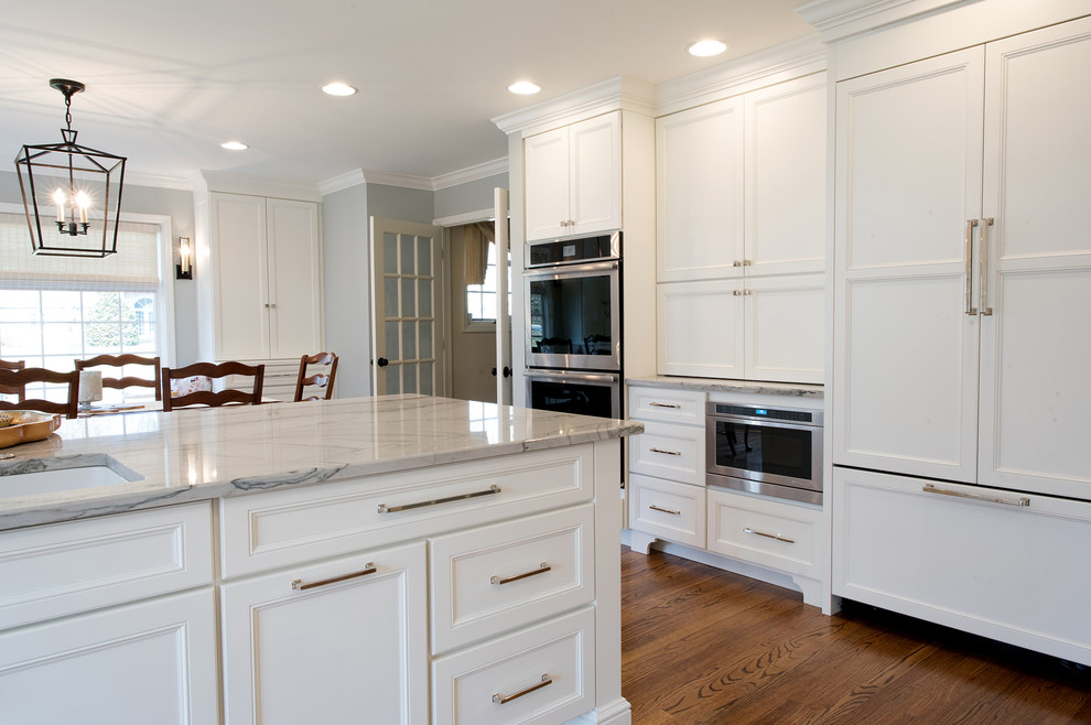 Large traditional galley eat-in kitchen in Philadelphia with an undermount sink, recessed-panel cabinets, white cabinets, quartzite benchtops, blue splashback, ceramic splashback, panelled appliances, medium hardwood floors and a peninsula.