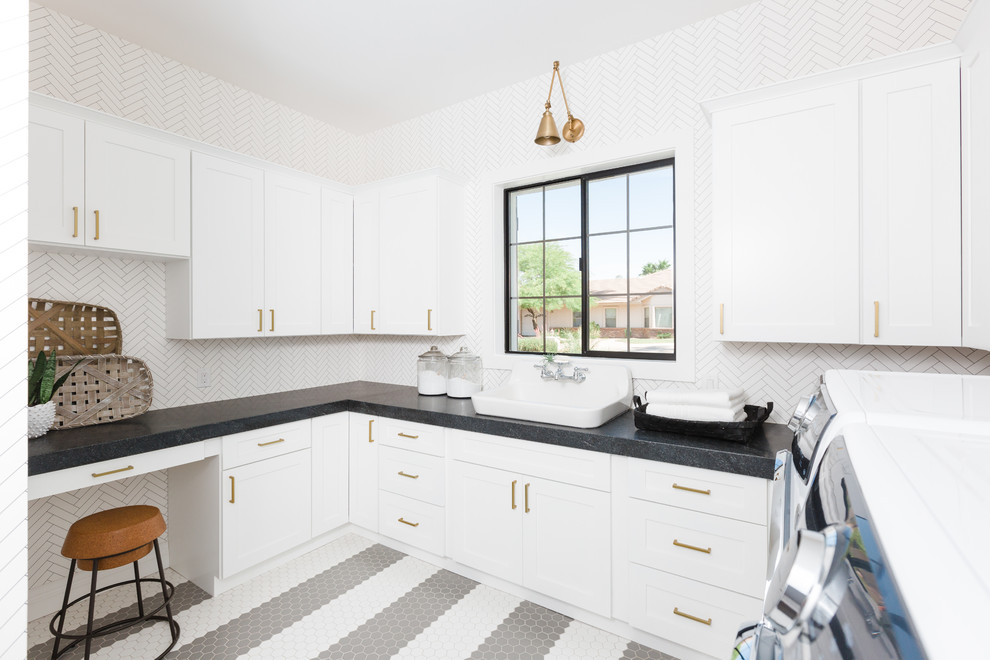 Photo of a mediterranean u-shaped dedicated laundry room in Phoenix with shaker cabinets, white cabinets, white walls, a side-by-side washer and dryer, multi-coloured floor and grey benchtop.