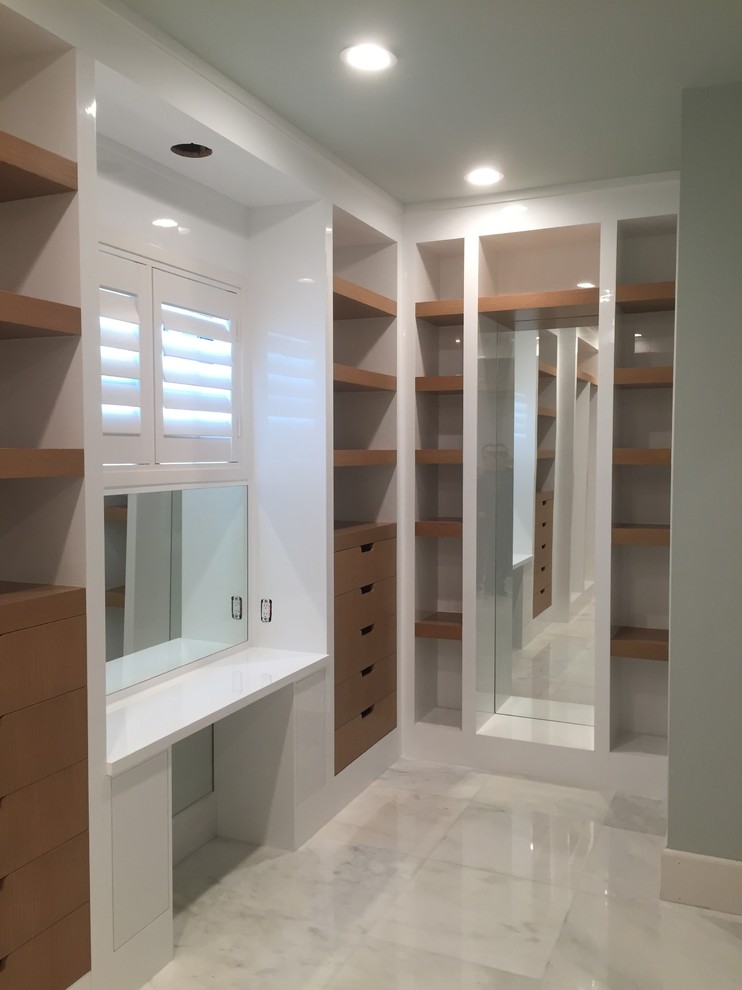 Design ideas for a large contemporary gender-neutral walk-in wardrobe in Miami with flat-panel cabinets, light wood cabinets and marble floors.