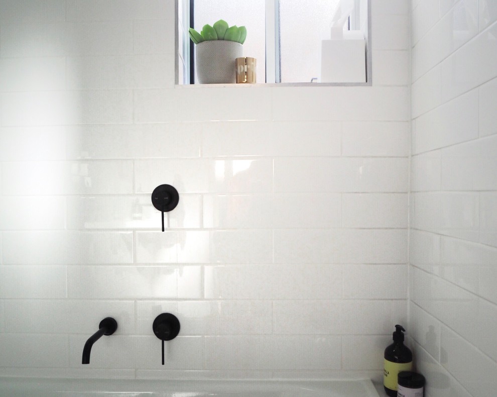 Inspiration for a small contemporary master bathroom in Adelaide with white cabinets, a drop-in tub, a shower/bathtub combo, a one-piece toilet, white tile, ceramic tile, white walls, mosaic tile floors, a wall-mount sink and multi-coloured floor.