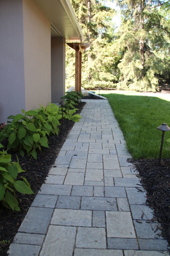 Inspiration for a mid-sized contemporary side yard garden in Calgary with concrete pavers.