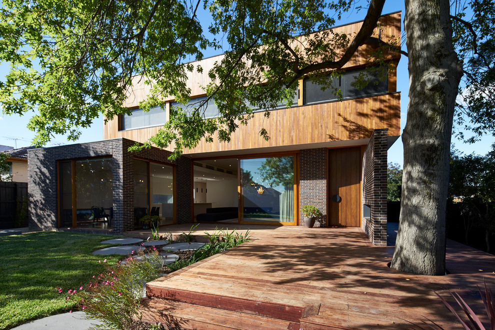 Photo of a contemporary two-storey exterior in Melbourne with wood siding.