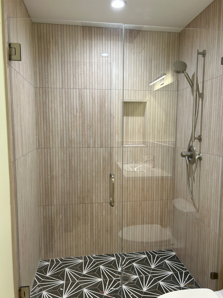Idéer för att renovera ett mellanstort badrum med dusch, med en dusch i en alkov, beige kakel, kakelplattor, svart golv och dusch med gångjärnsdörr