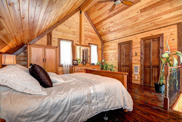Inspiration for a small country loft-style bedroom in Charlotte with brown walls and medium hardwood floors.