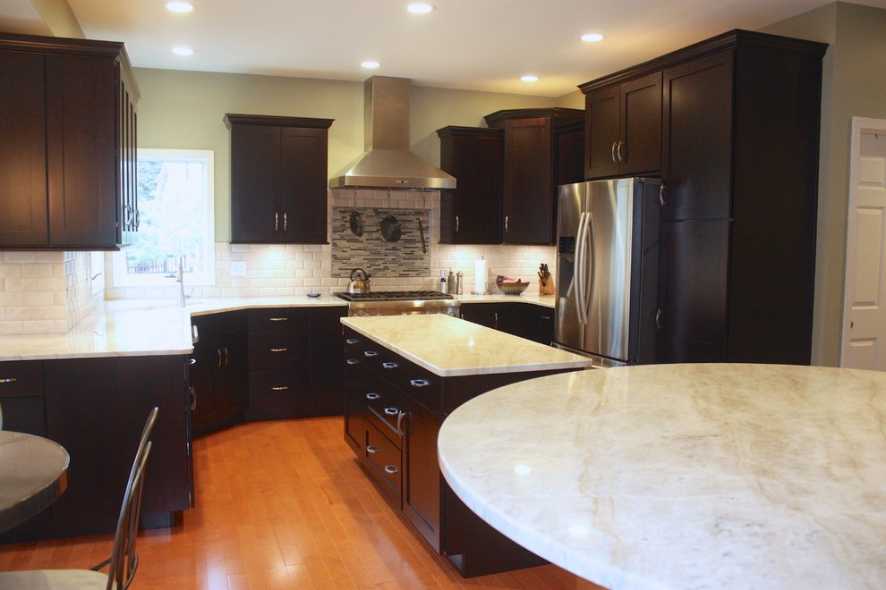 Example of a mid-sized minimalist u-shaped medium tone wood floor eat-in kitchen design with shaker cabinets, dark wood cabinets, white backsplash, stainless steel appliances, an island, a double-bowl sink and subway tile backsplash
