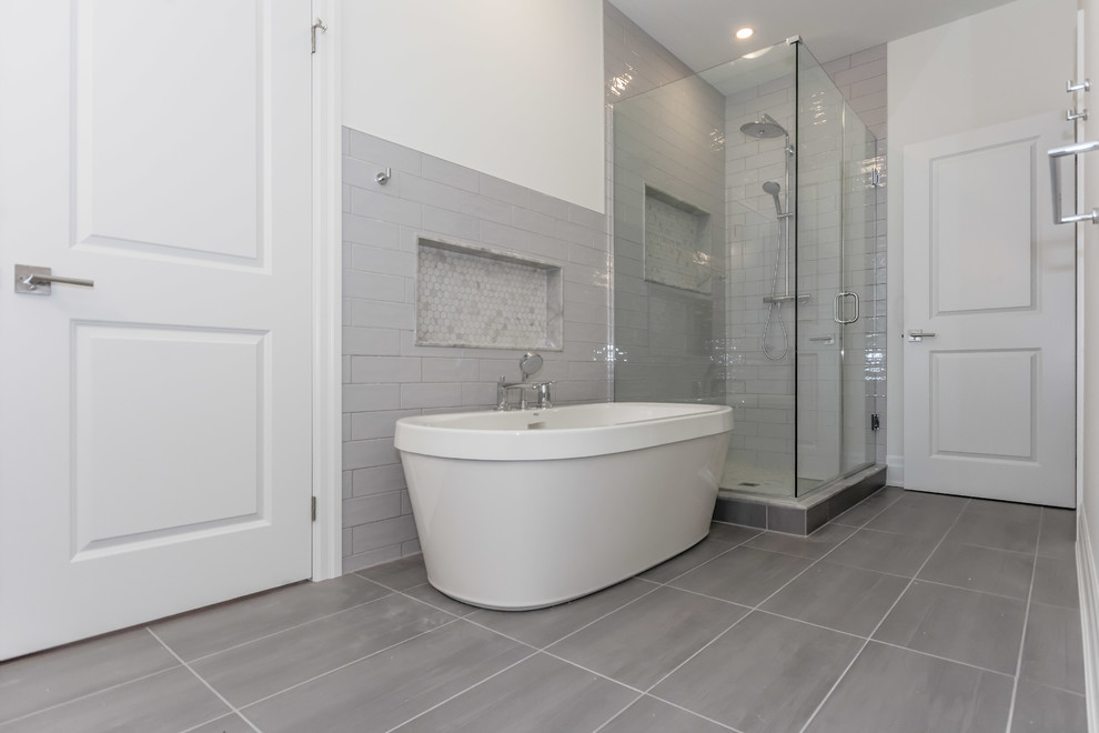 Large transitional master bathroom in Toronto with a freestanding tub, a corner shower, gray tile, ceramic tile, grey walls, porcelain floors, grey floor and a hinged shower door.