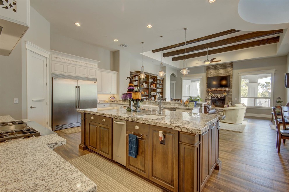Eat-in kitchen - large transitional u-shaped medium tone wood floor eat-in kitchen idea in Phoenix with an undermount sink, shaker cabinets, white cabinets, granite countertops, gray backsplash, stone tile backsplash, stainless steel appliances and an island