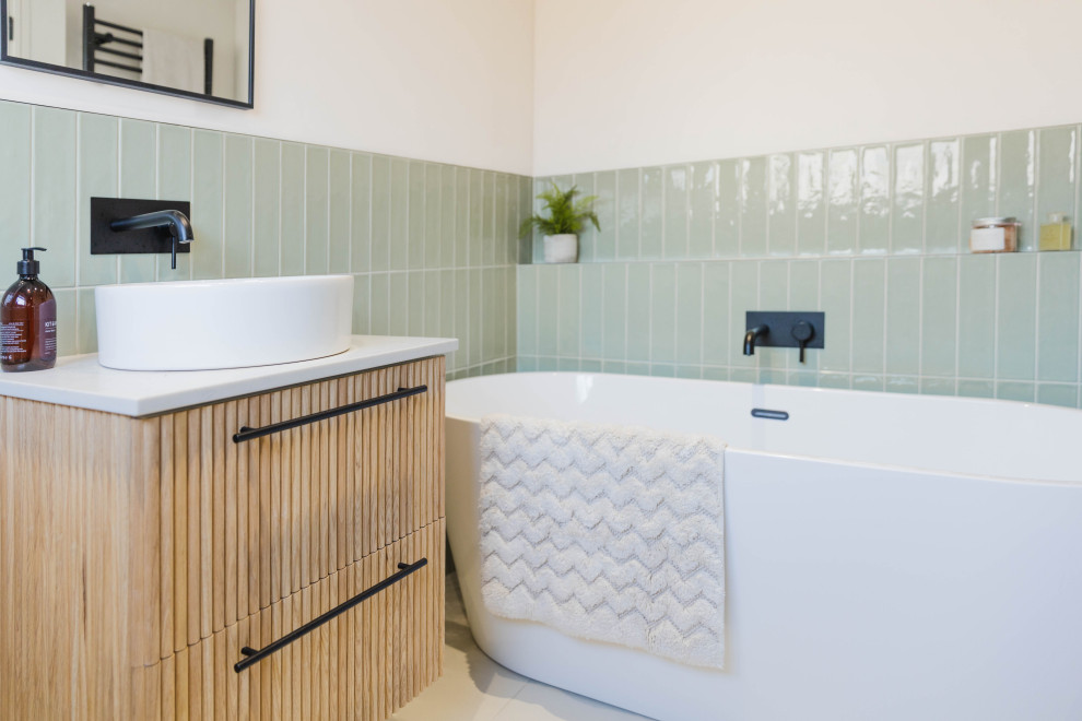 Inspiration for a mid-sized scandinavian bathroom in Sussex with light wood cabinets, a freestanding tub, green tile, ceramic tile, beige walls, a console sink, quartzite benchtops, white benchtops, a single vanity and a floating vanity.