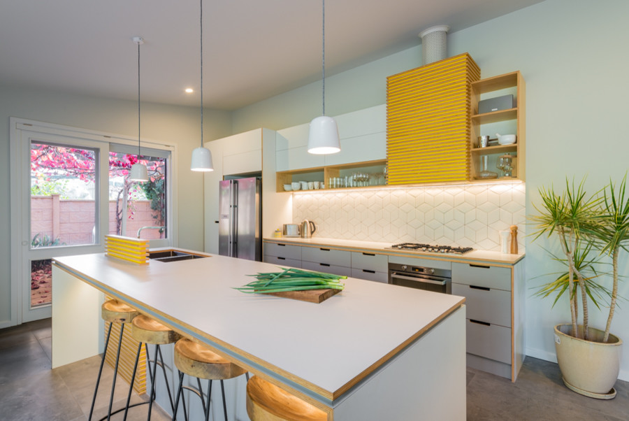 Photo of a large midcentury galley eat-in kitchen in Adelaide with an undermount sink, flat-panel cabinets, grey cabinets, laminate benchtops, white splashback, ceramic splashback, stainless steel appliances, ceramic floors and with island.
