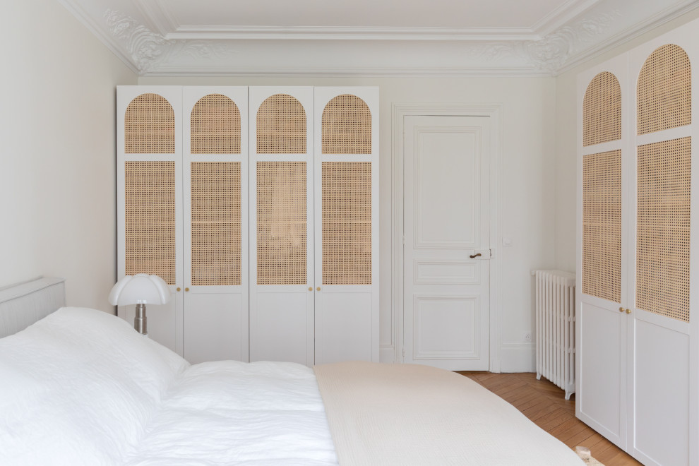 Exemple d'une grande chambre parentale beige et blanche scandinave avec un mur blanc, parquet clair et dressing.