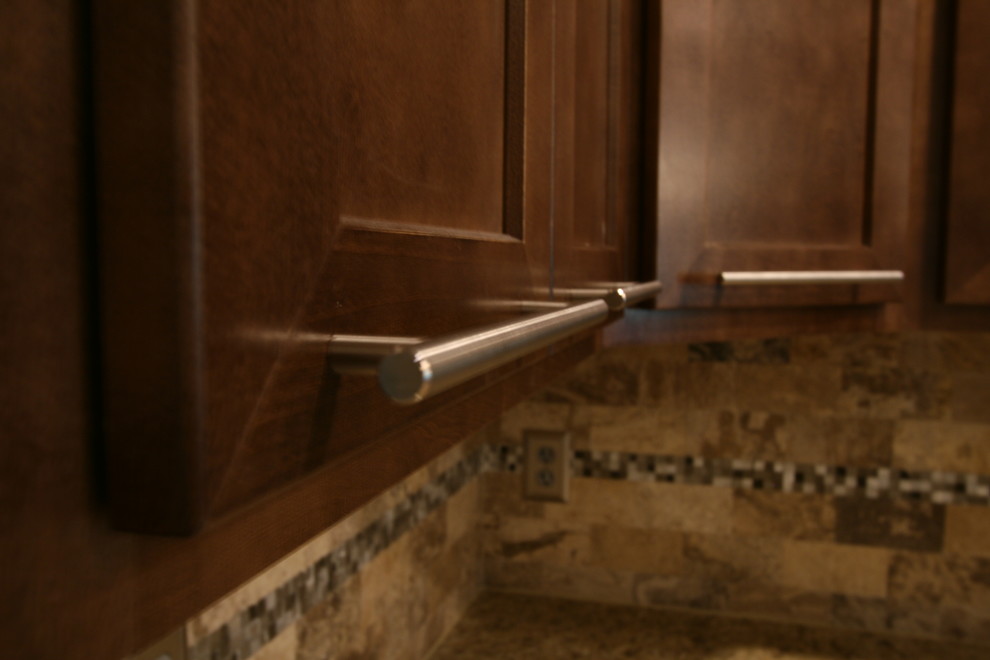 Inspiration for a mid-sized transitional l-shaped porcelain tile eat-in kitchen remodel in Jacksonville with an undermount sink, shaker cabinets, brown cabinets, granite countertops, beige backsplash, stone tile backsplash, stainless steel appliances and a peninsula