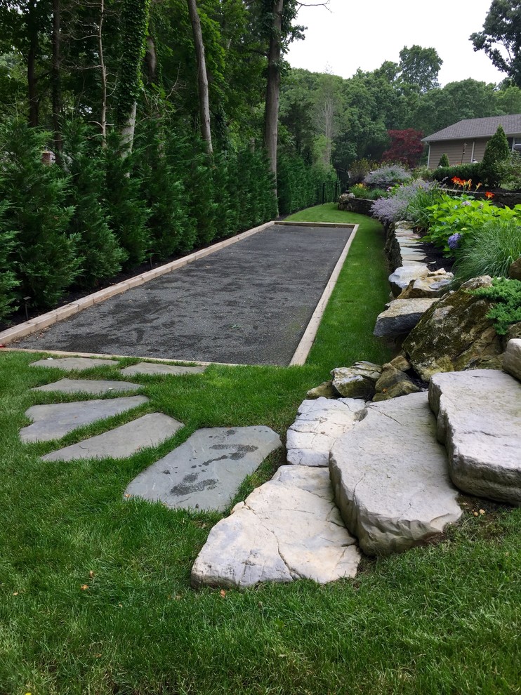 Photo of a large transitional backyard partial sun outdoor sport court for summer in New York with natural stone pavers.