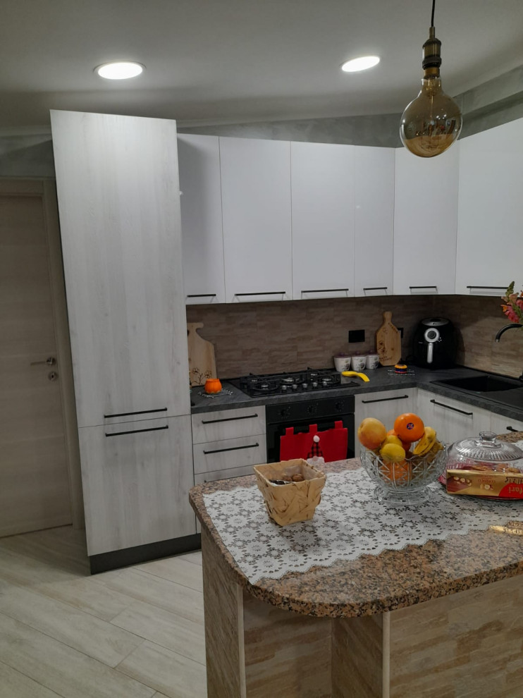 Photo of an expansive modern l-shaped open plan kitchen in Rome with a double-bowl sink, flat-panel cabinets, grey cabinets, laminate countertops, black appliances, terracotta flooring, an island, beige floors, black worktops and a coffered ceiling.
