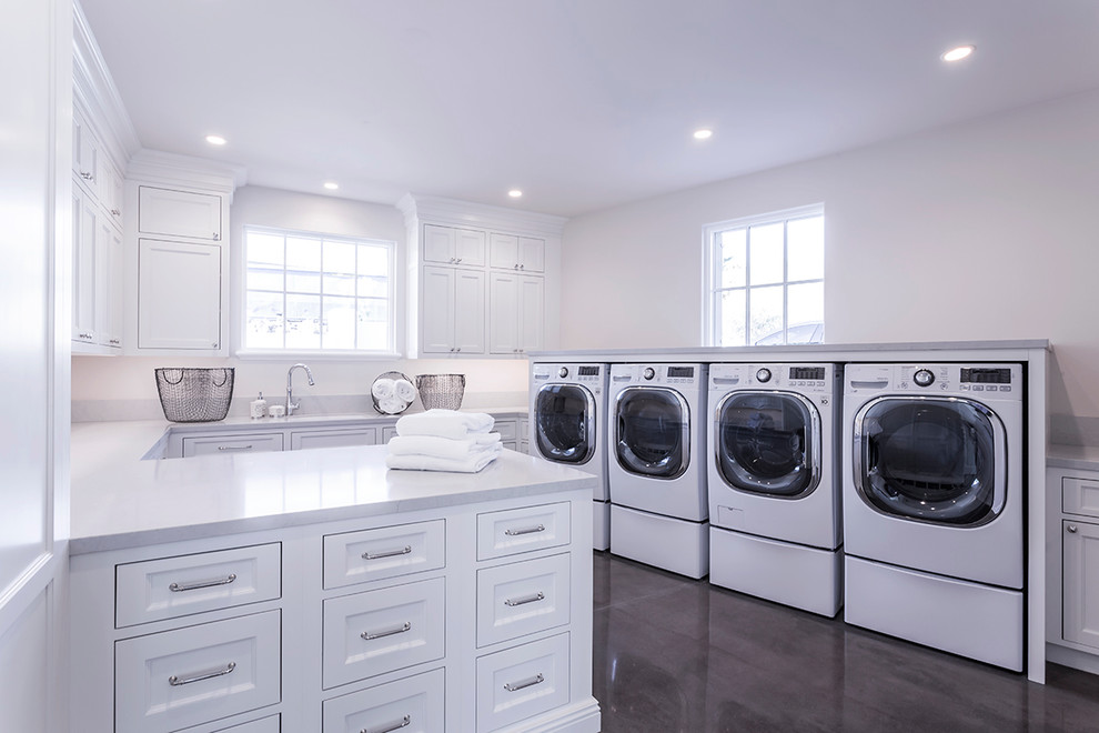 This is an example of an expansive transitional u-shaped dedicated laundry room in Phoenix with shaker cabinets, white cabinets, solid surface benchtops, white walls, dark hardwood floors, a side-by-side washer and dryer and brown floor.