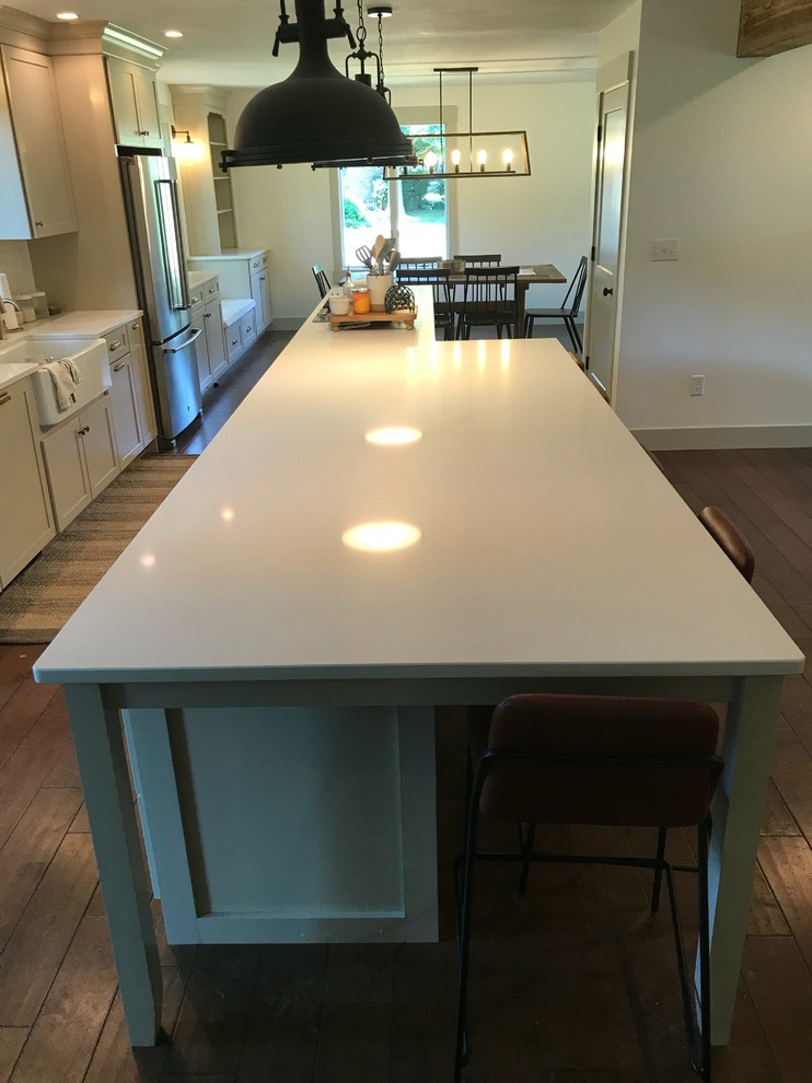 Inspiration for a large transitional galley dark wood floor and brown floor eat-in kitchen remodel in Chicago with a farmhouse sink, shaker cabinets, beige cabinets, quartz countertops, white backsplash, subway tile backsplash, stainless steel appliances, an island and white countertops