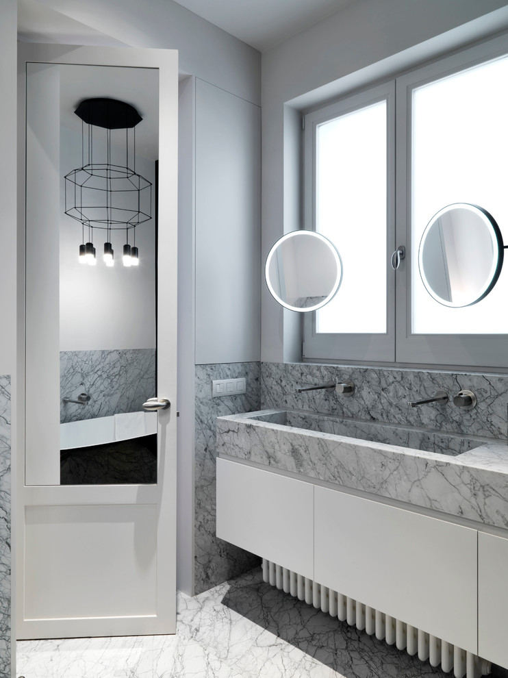 Design ideas for a contemporary master bathroom in Madrid with flat-panel cabinets, white cabinets, gray tile, marble, white walls, marble floors, a trough sink, marble benchtops and grey floor.