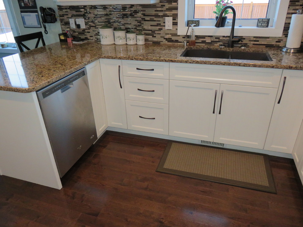 Inspiration for a mid-sized transitional u-shaped dark wood floor eat-in kitchen remodel with white cabinets, quartz countertops, stainless steel appliances, a peninsula, matchstick tile backsplash, a double-bowl sink, shaker cabinets and brown backsplash