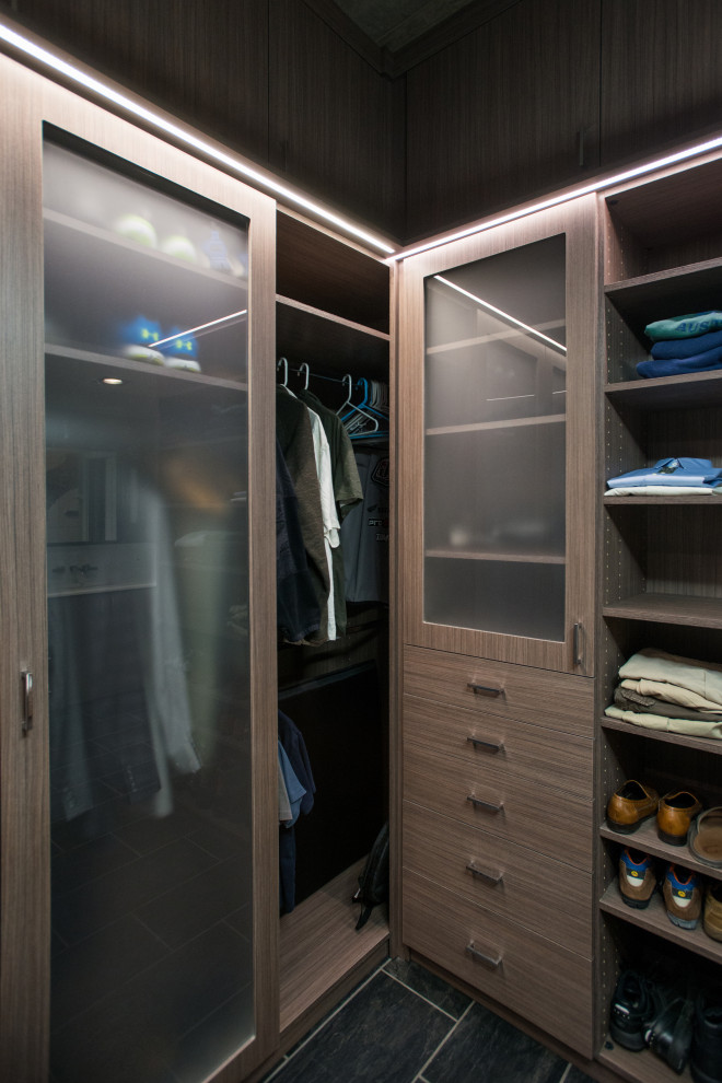 Inspiration for a mid-sized modern men's walk-in wardrobe in Denver with flat-panel cabinets, medium wood cabinets, ceramic floors, grey floor and vaulted.