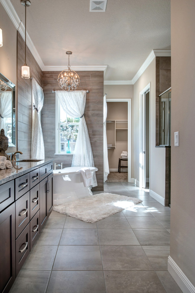 This is an example of a transitional master bathroom in Orlando with recessed-panel cabinets, brown cabinets, a freestanding tub, brown walls, an undermount sink and brown floor.