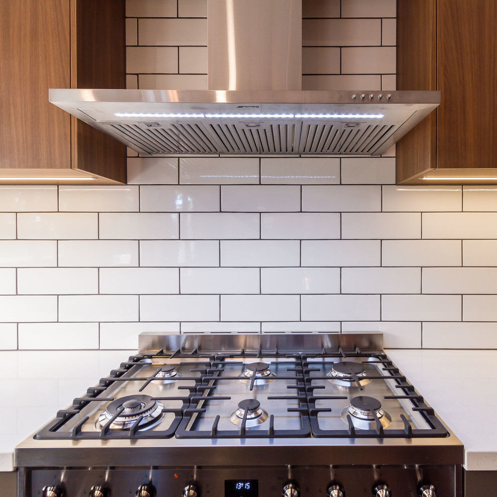 Mid-sized midcentury u-shaped eat-in kitchen in Melbourne with a drop-in sink, flat-panel cabinets, grey cabinets, quartz benchtops, white splashback, ceramic splashback, stainless steel appliances, slate floors, a peninsula, grey floor and white benchtop.