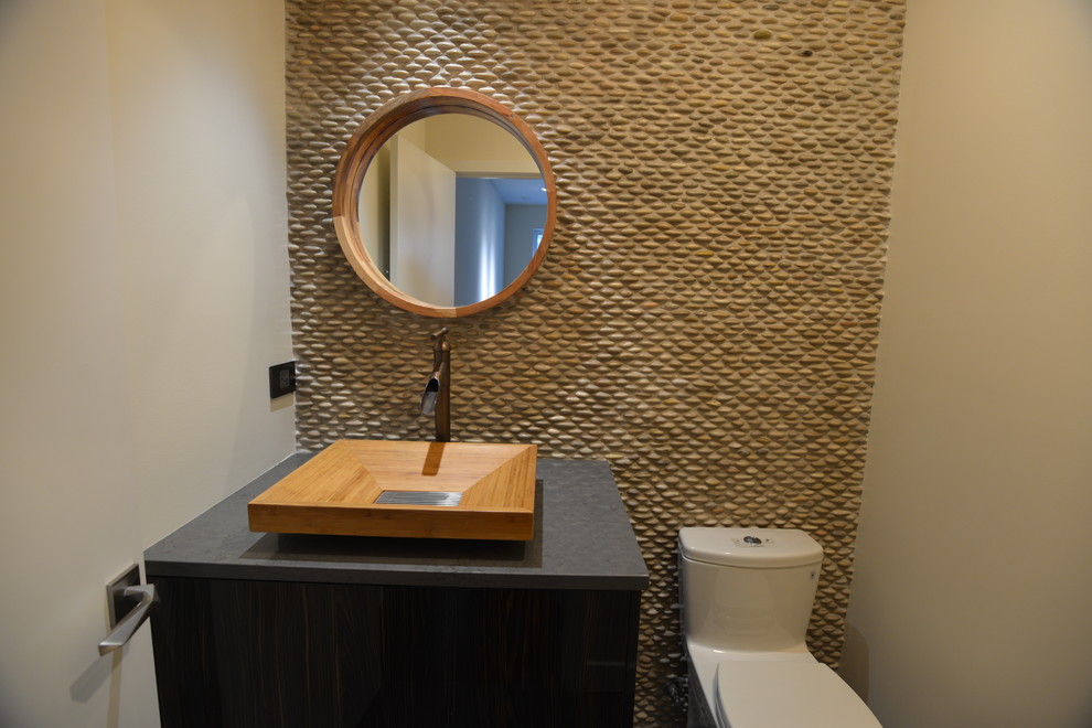Inspiration for a midcentury powder room in Chicago with dark wood cabinets, pebble tile and a pedestal sink.