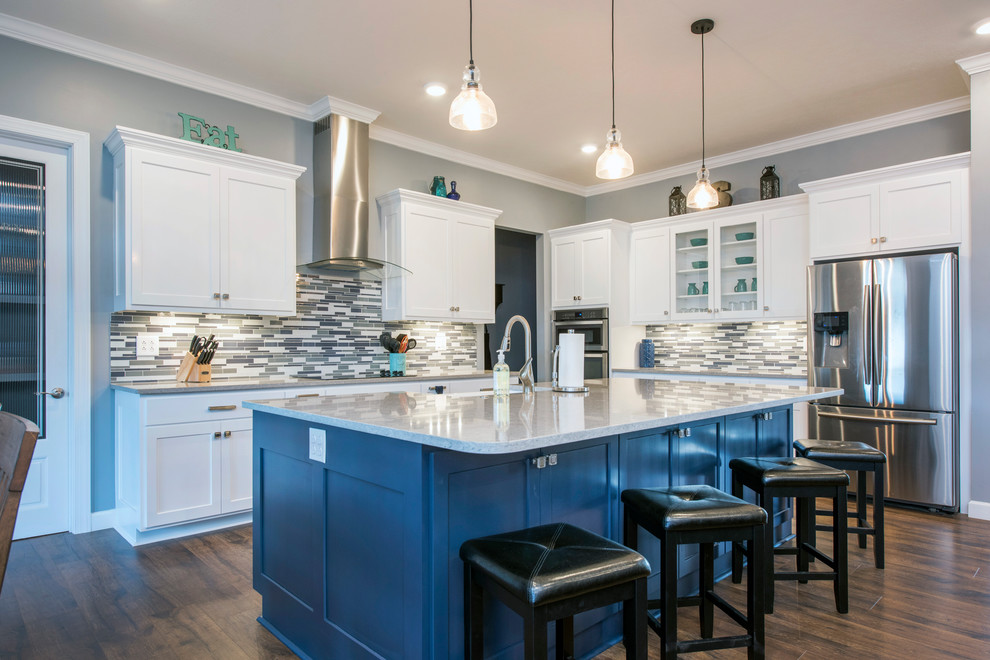 Example of a transitional l-shaped dark wood floor kitchen design in Columbus with a farmhouse sink, shaker cabinets, blue cabinets, matchstick tile backsplash, stainless steel appliances and an island