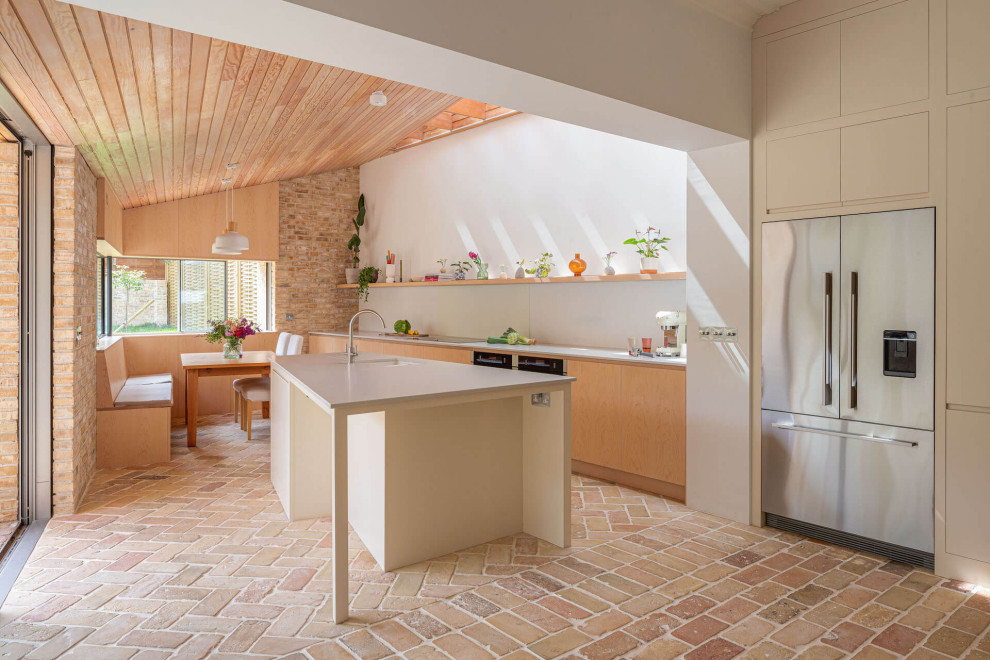 Immagine di una grande cucina nordica con ante lisce, ante in legno chiaro, top in superficie solida, pavimento in mattoni e top grigio
