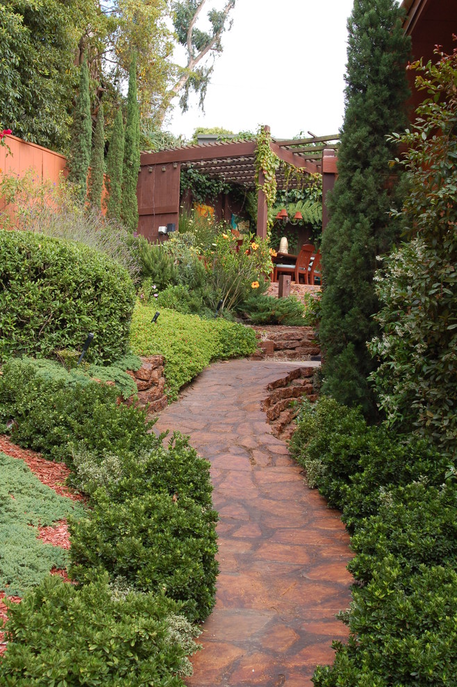 Design ideas for a traditional backyard garden in Orange County with natural stone pavers.