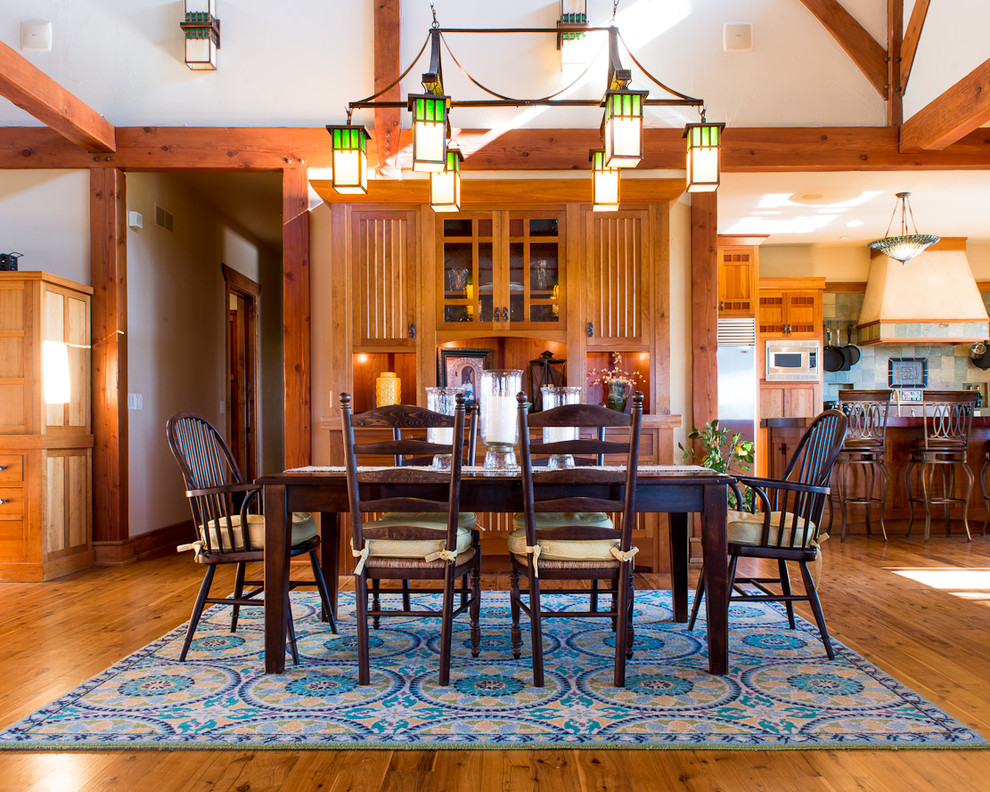 This is an example of a mid-sized arts and crafts open plan dining in Denver with white walls and medium hardwood floors.