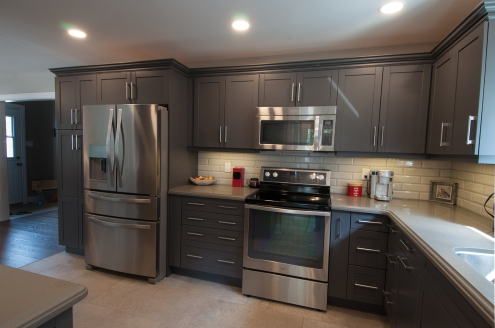 Mid-sized transitional u-shaped ceramic tile and beige floor enclosed kitchen photo in Toronto with a double-bowl sink, shaker cabinets, dark wood cabinets, quartzite countertops, beige backsplash, subway tile backsplash, stainless steel appliances and no island